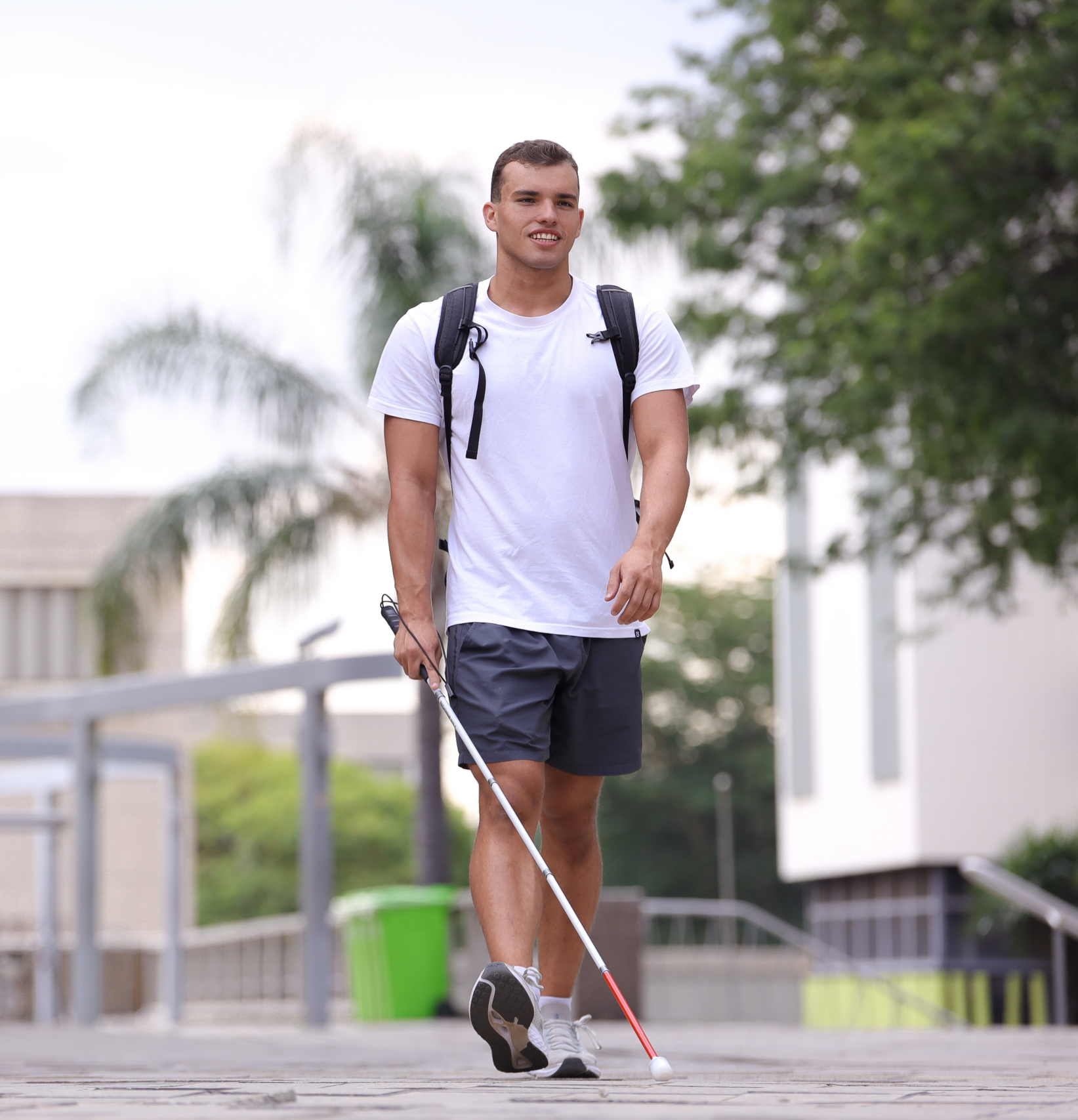 Person using a white cane while walking independently